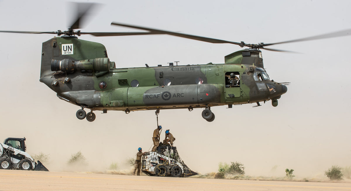 CH-147F Chinook helicopter hooking up an underslung load in the desert